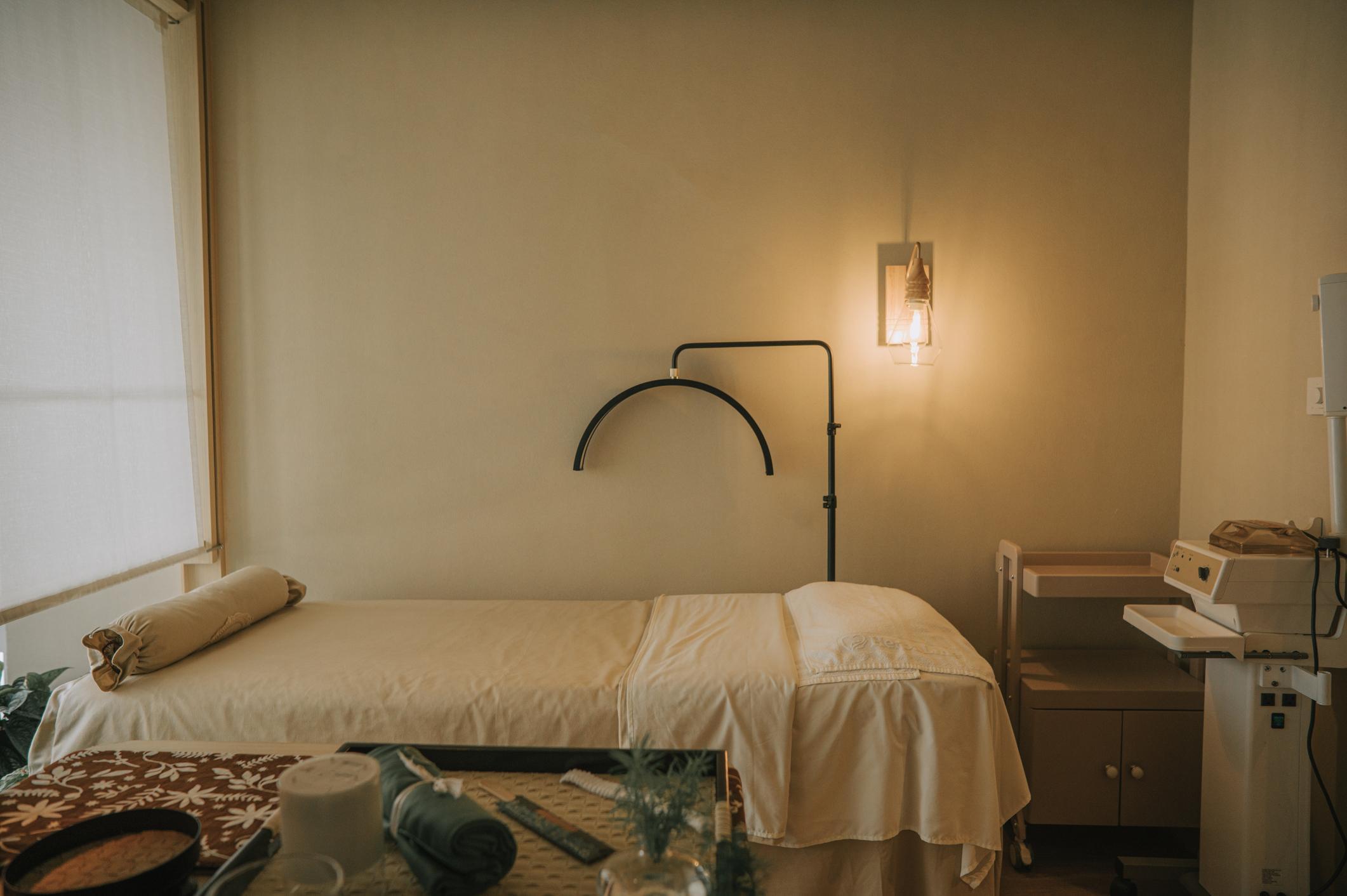 Treatment room bathed in warm amber lamplight — quiet, private, unhurried